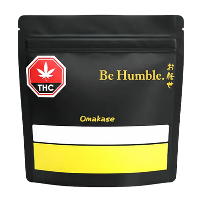 Front-facing shot of the black pouch labeled "Omakase" with gold "Be Humble." text and a red THC symbol.