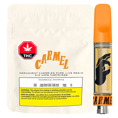 Front-lit product shot of the Permanent Cherreis Pure Live Resin Vape Cartridge showing a cream pouch labeled "CARMEL" beside a clear cartridge with an orange mouthpiece and black hand graphic.