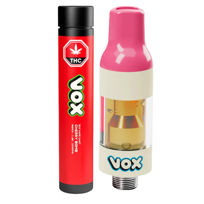 Close-up of a pink-topped VOX Cherry Bomb Vape Cartridge beside its red VOX-branded tube, shown on a white background.