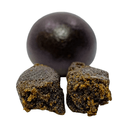 A close-up, angled view of the dark brown Afghan Black Pressed Hash, showing its roughly textured, pressed form.