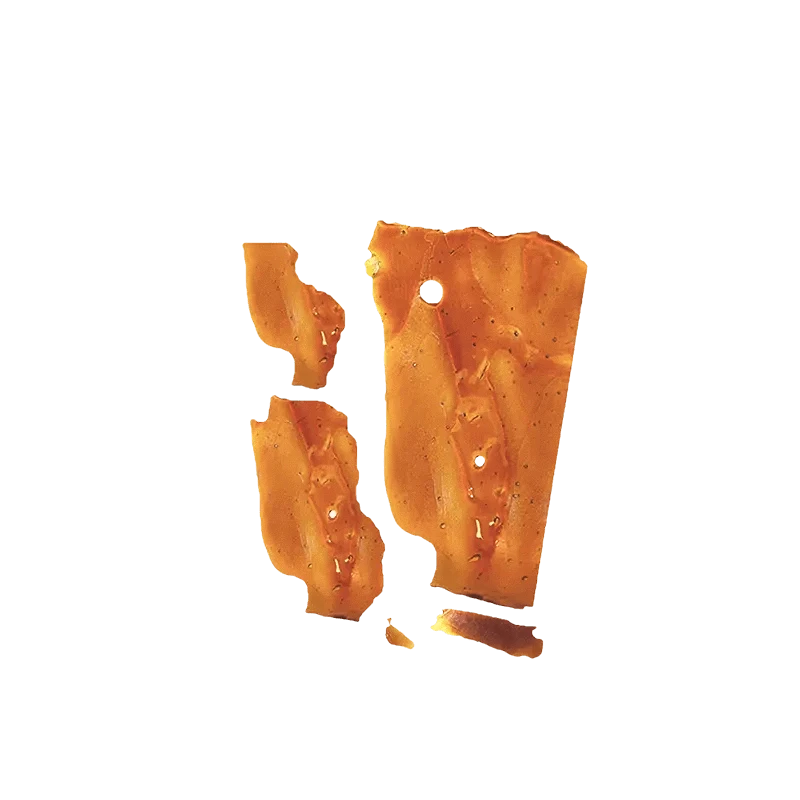 A close-up view of Pink Kush Shatter, showcasing its translucent amber color and fractured, glassy texture.