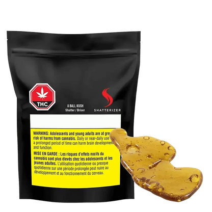 Close-up of the 8 Ball Kush Shatter against a black background, showcasing its branding and textured surface.