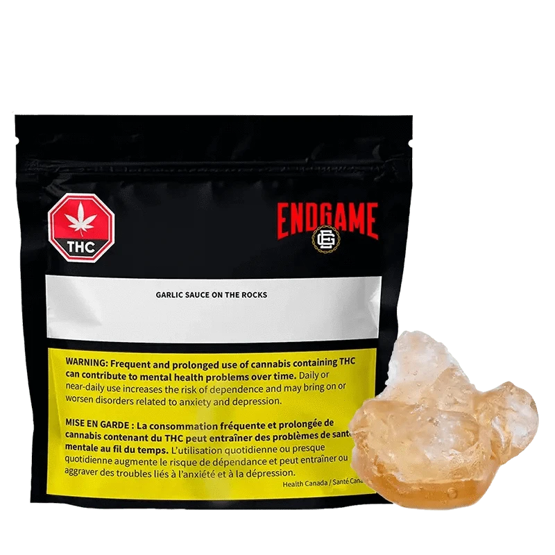 Close-up of the “Garlic Sauce on the Rocks Diamonds and Terp Sauce” packaging with a warning label and THC symbol against a dark backdrop.