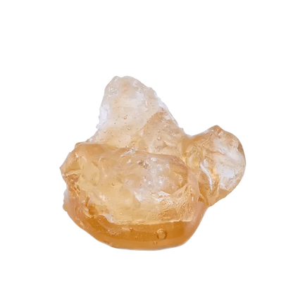 A close-up view of Garlic Sauce on the Rocks Diamonds and Terp Sauce with a translucent, rocky texture, illuminated against a bright background.