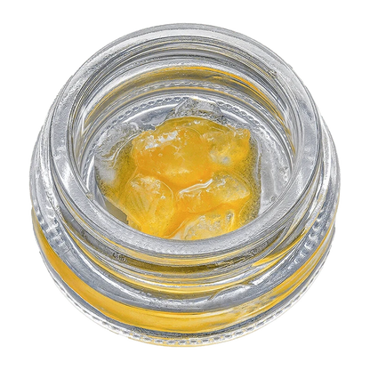 Overhead view of Fruit Sauce on the Rocks, a golden, viscous substance filling a clear glass container.