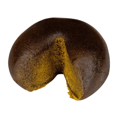 Close-up of the Haschtag STRWBRRY, a dark, rounded piece with a textured surface and a visible indentation.