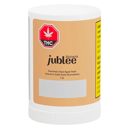 Front view of the Jubilee Extracts Montreal-Style Aged Hash white plastic jar with a tan label, THC emblem, and legible product text.