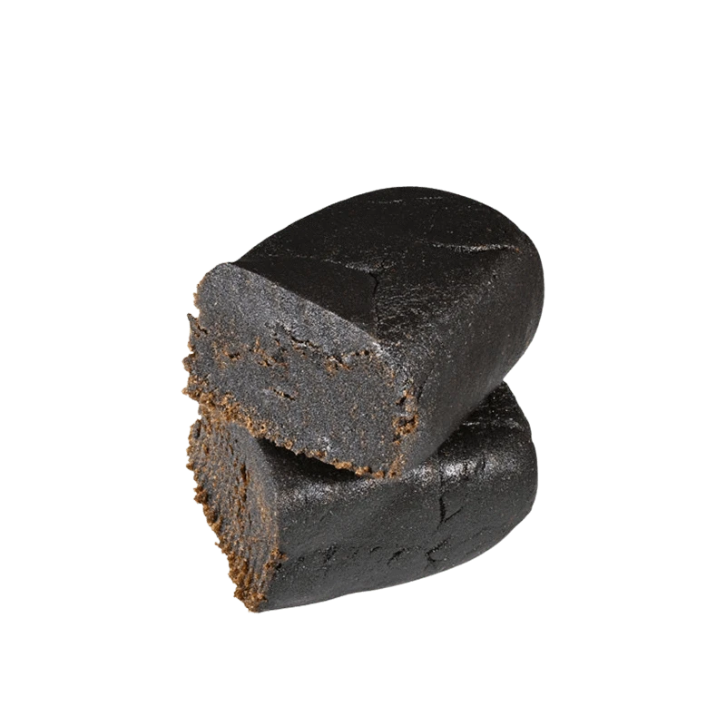 Close-up of a dark, blocky piece of Afghan Hash, angled against a plain white background.