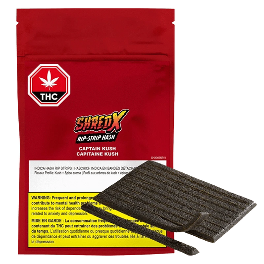 A close-up of the Captain Kush Rip Strips packaging with bold graphics, a tilted angle, and a dark background.