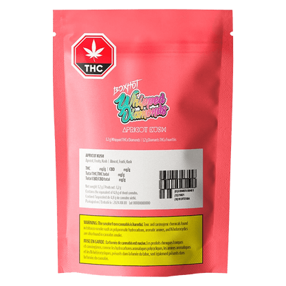 Close-up of Apricot Kush Diamonds packaging with bold lettering and THC/CBD information on a dark background.