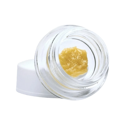 A close-up, top-down view of Tangerine Punch Live Resin, showcasing its golden, textured surface in a clear container.