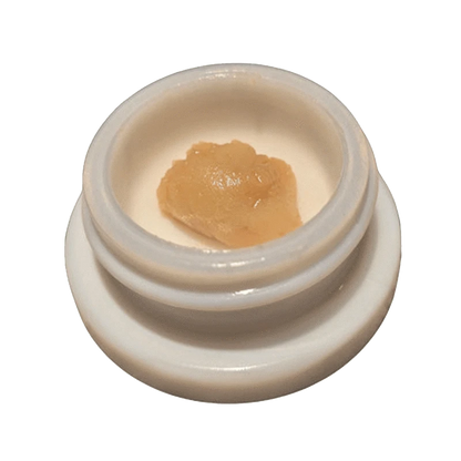 Close-up of Papaya C. Live Rosin with a golden hue, captured in a top-down view against a neutral background.