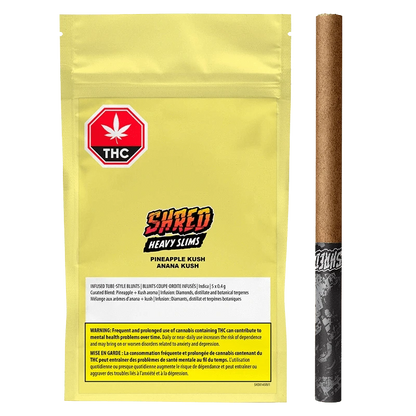 Flat front view of the yellow pouch and slim pre-roll arranged side-by-side, labeled "Pineapple Kush Heavy Slims Infused PR 5 x 0.4 g" with a red THC octagon and bold "SHRED" logo.