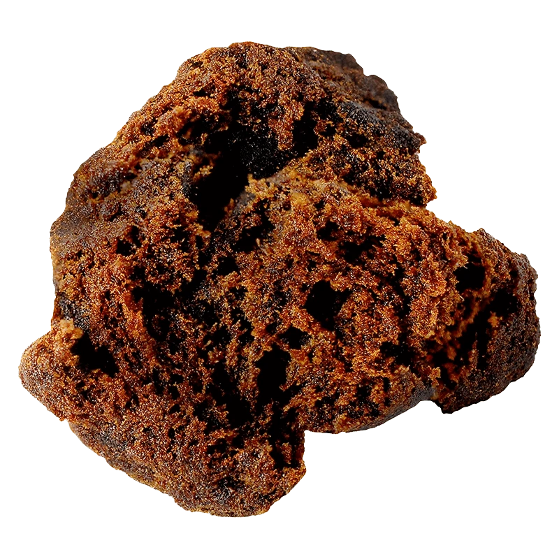 Close-up of a crumbly dark brown chunk of Afghan Black Hash shown against a transparent background, highlighting its porous texture.