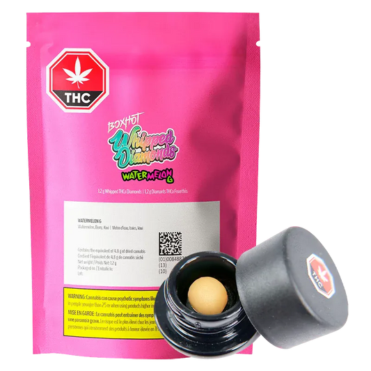 Front-facing shot of a bright pink pouch and open black jar showing a pale yellow concentrate ball, labeled Watermelon G Whipped Diamonds.