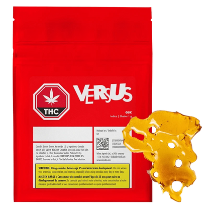 Front view of the red VERSUS GSC Shatter pouch with a golden amber slab of shatter placed overlapping its lower right corner.
