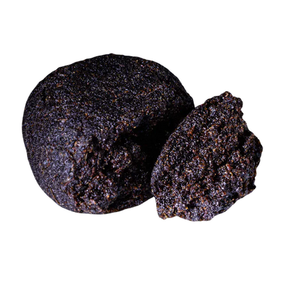Close-up front view of a dark, crumbly ball and a halved piece of Bubble Yum Hash showing its granular, glistening texture.
