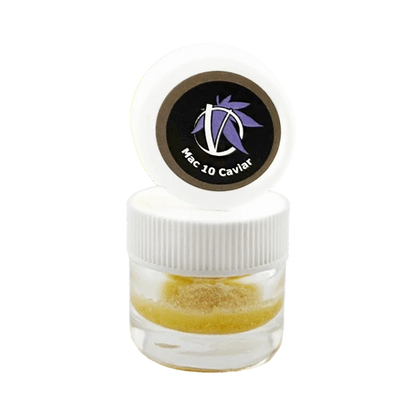 Close-up front view of a small clear jar with a white ribbed lid and opened cap showing a circular black logo reading "Mac 10 Caviar" above golden crumble inside, Mac 10 Caviar