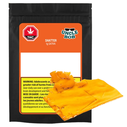 Front-facing shot of the Uncle Bob Sativa Shatter 1 g pouch with bright orange label and amber translucent shatter pieces overlapping the package.