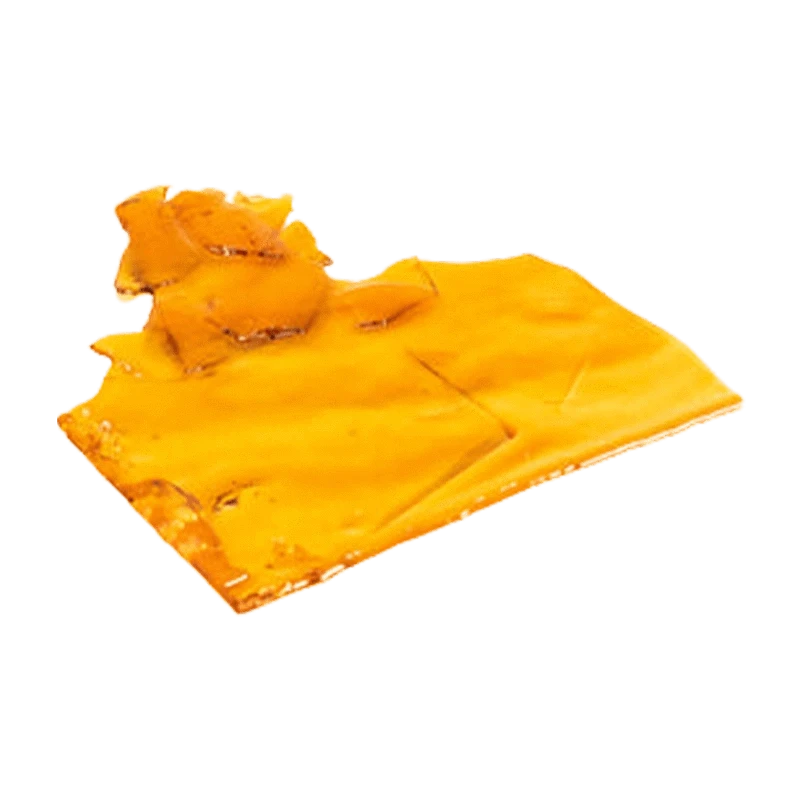 Close-up, angled view of a glossy amber slab of Sativa Shatter resting on a white background.