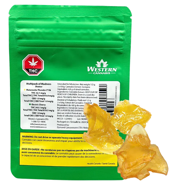 Rear view of the green Western Cannabis Orange Creamsicle Shatter pouch with amber shatter pieces arranged at its base.