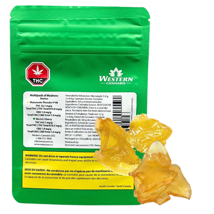 Rear view of the green Western Cannabis Orange Creamsicle Shatter pouch with amber shatter pieces arranged at its base.