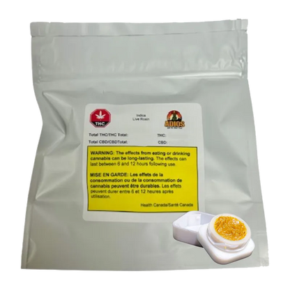 Front-facing shot of Goldie Knox Jar Live Rosin in a silver foil pouch with warning label and a small open white jar of amber concentrate.