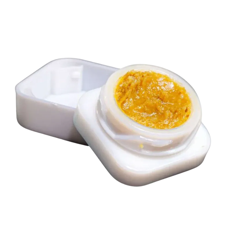 Close-up of an open white container showing golden concentrate inside, labeled Slurricane Jar Live Rosin.