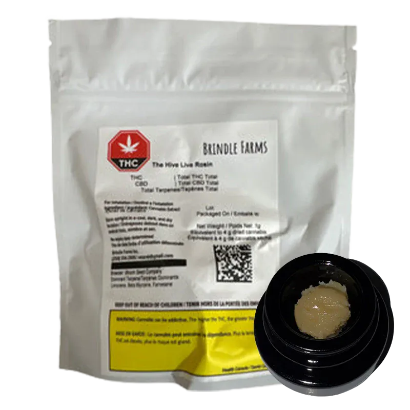 White pouch with a printed label and a small black jar showing pale, crumbly concentrate in the foreground of The Hive Live Rosin image.