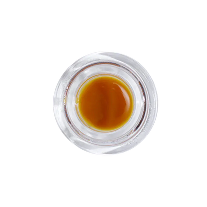 Top-down view of a small glass jar of Pineapple Garlic Live Rosin showing glossy amber concentrate against a white background