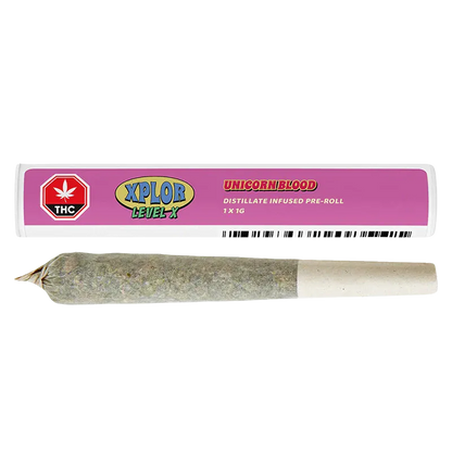 Close-up of a rolled pre-roll below its pink tube packaging labeled "Unicorn Blood Distillate Infused PR 1 x 1 g" and XPLOR branding.
