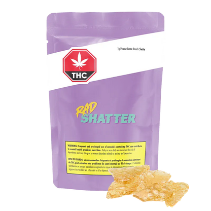 Front-view of a purple pouch labeled "Peanut Butter Breath Shatter" with teal "RAD SHATTER" text and amber shatter pieces at its base.