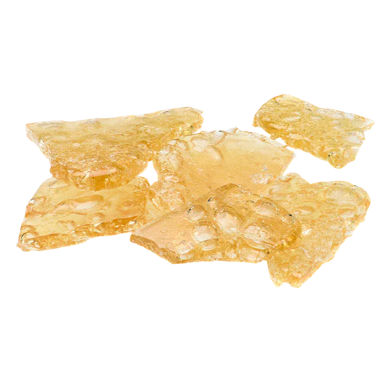 Close-up of amber, translucent shards of Peanut Butter Breath Shatter arranged on a white background.