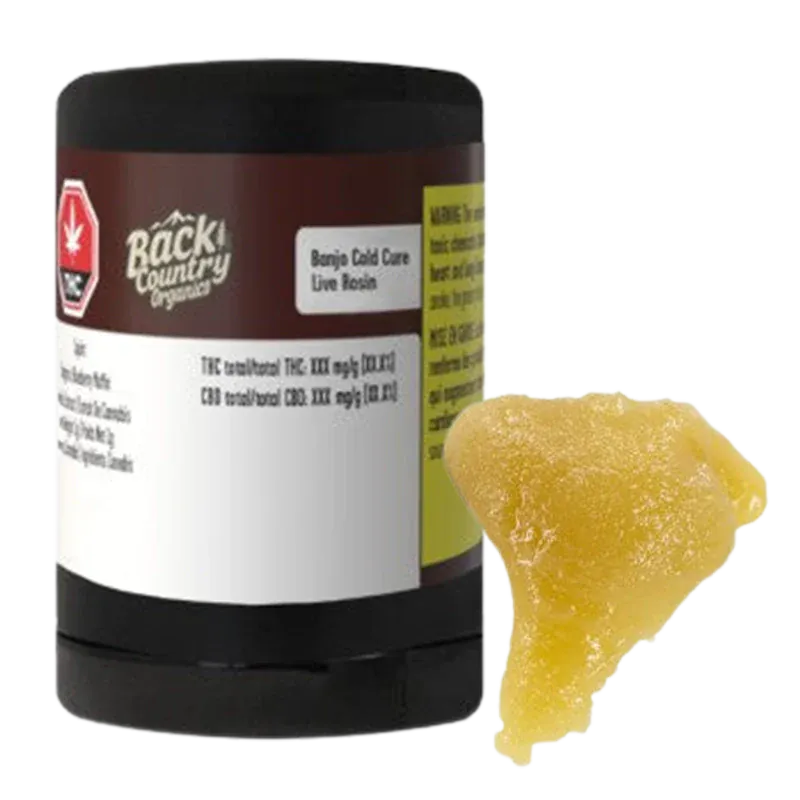 A front three-quarter view of a black tub next to a golden, sticky piece of concentrate labeled "Banjo Cold Cure Live Rosin."