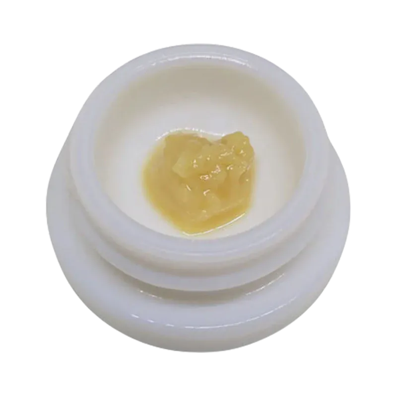 Top-down close-up of a pale yellow concentrate blob in a white jar labeled Rainbow Guava Live Rosin.