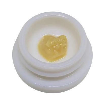 Top-down close-up of a pale yellow concentrate blob in a white jar labeled Rainbow Guava Live Rosin.