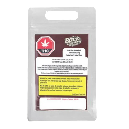 Front-facing shot of a silver pouch labeled "Kush Mints Classic Gummy Hash" with a maroon panel, THC stop sign icon, and yellow warning box.