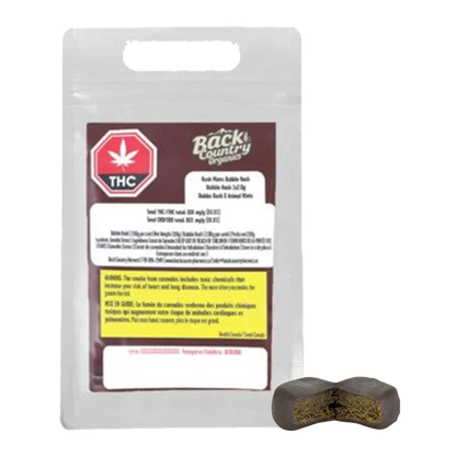 Front view of the packaged Back Country Organics Kush Mints Classic Gummy Hash with a bitten dark brown gummy shown at lower right.