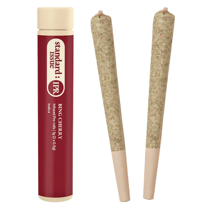 Studio-lit front view of the Bing Cherry Infused PR 2 x 0.5 g tube standing next to two rolled joints on a white background
