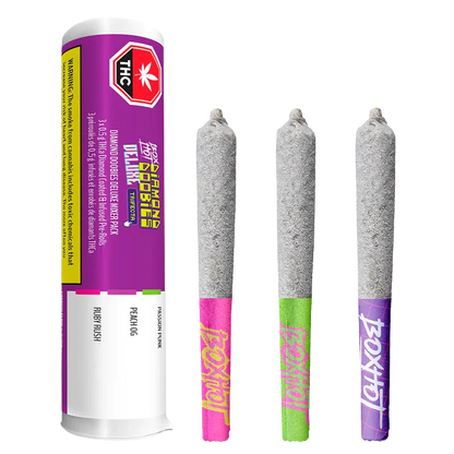 Three quarter view of a tube and three ash-coated pre-rolls arranged upright, labeled "Diamond Doobies Deluxe Trifecta Infused PR 3 x 0.5 g" on the purple tube.