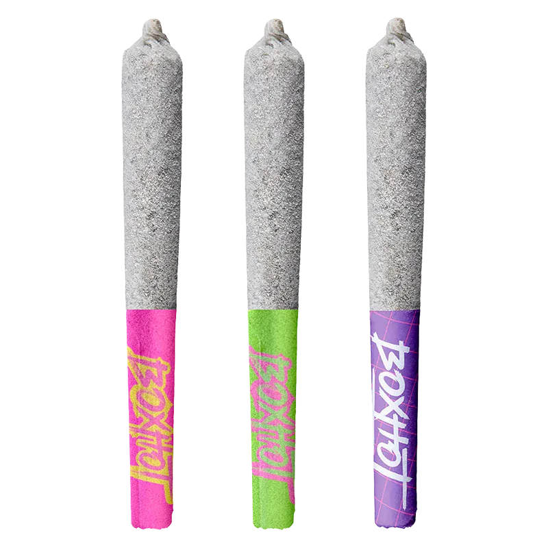 Three-quarter front view of three Diamond Doobies Deluxe Trifecta Infused PR 3 x 0.5 g pre-rolls standing upright, each with a grey ash-coated cone and bright pink, green, and purple branded paper tips.