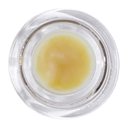 Top-down view of a small jar of Grapefruit Mac Live Rosin showing its pale yellow, creamy concentrate against a white background.