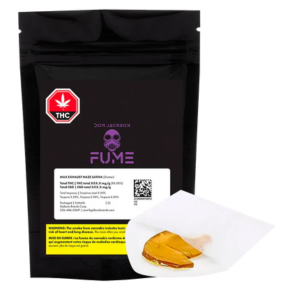 Front-facing shot of a black pouch labeled "Max Exhaust Haze Shatter" with purple FUME logo and a piece of amber shatter on white parchment in the foreground
