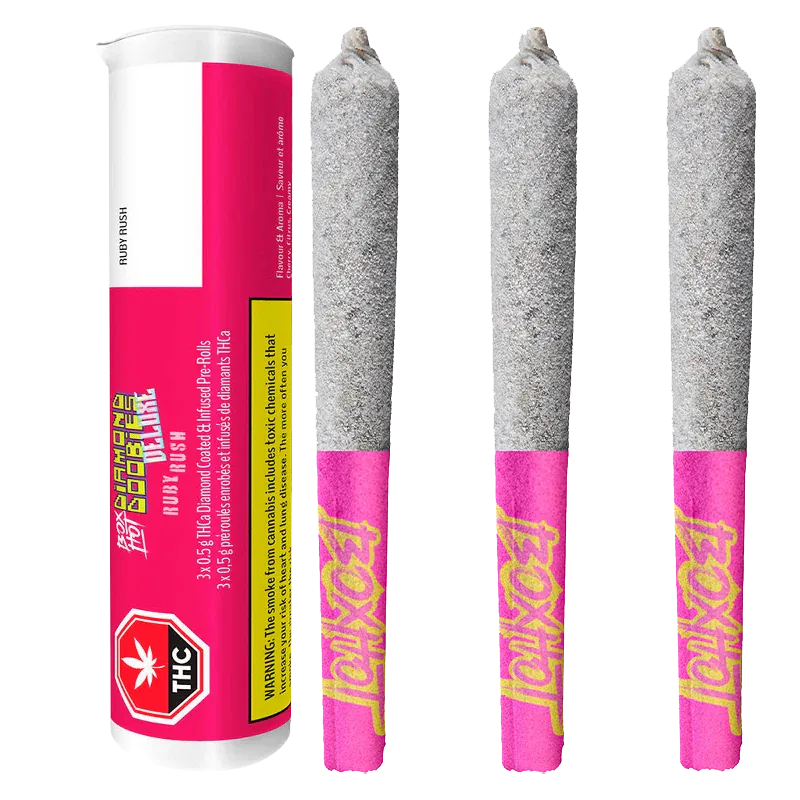Three-quarter view of a tube and three ash-coated joints with pink branded tips reading "Diamond Doobies Deluxe Ruby Rush Infused PR 3 x 0.5 g."