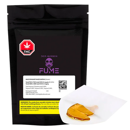 Front-facing shot of a black pouch and a piece of amber concentrate on white parchment, showing the "Exhaust Haze Shatter" FUME packaging.
