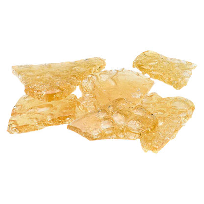 Close-up top-down view of amber, glassy shatter pieces labeled Mango Kush x Galactic Giggles Shatter scattered on a white background