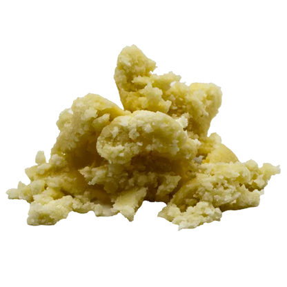 Close-up of a pale yellow crumbly mound on white background, labeled in context as Pineapple Glimmer Whipped Diamonds.
