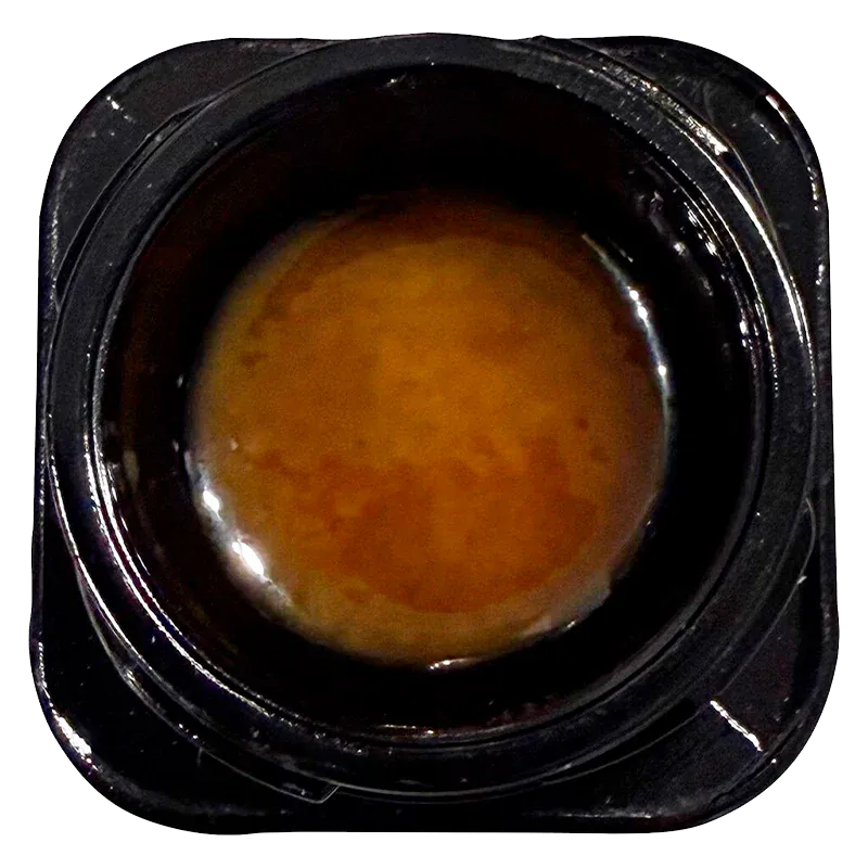 Top-down close-up of a glossy amber concentrate inside its black plastic jar labeled Live Rosin Reserve.