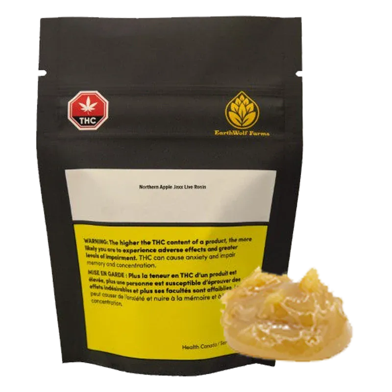 Front view of a black pouch labeled Northern Apple Jaxx Live Rosin with a yellow warning panel, shown behind a glossy amber dab of concentrate.