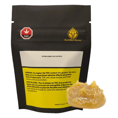 Front view of a black pouch labeled Northern Apple Jaxx Live Rosin with a yellow warning panel, shown behind a glossy amber dab of concentrate.